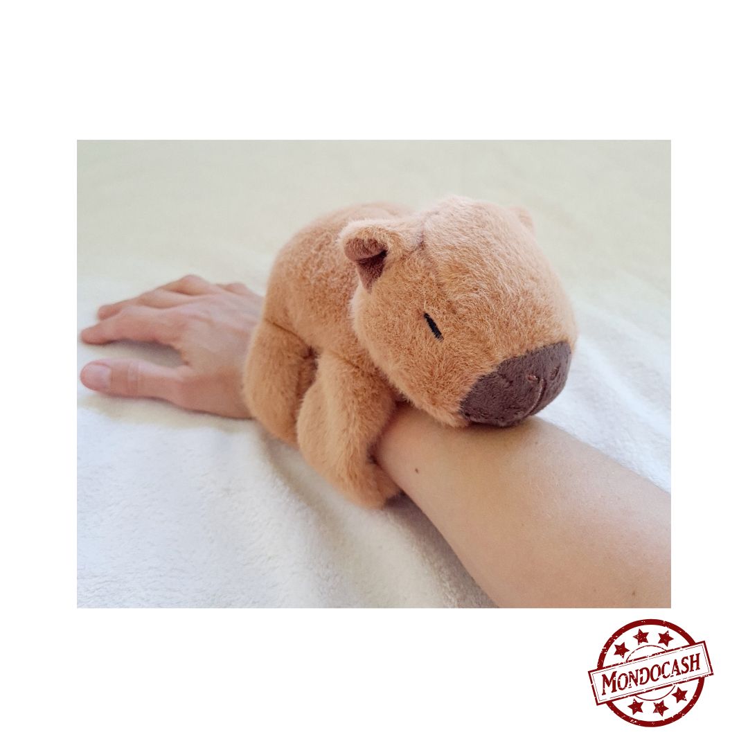 Peluche capybara de couleur marron à accrocher à son bras grâce au bracelet slap